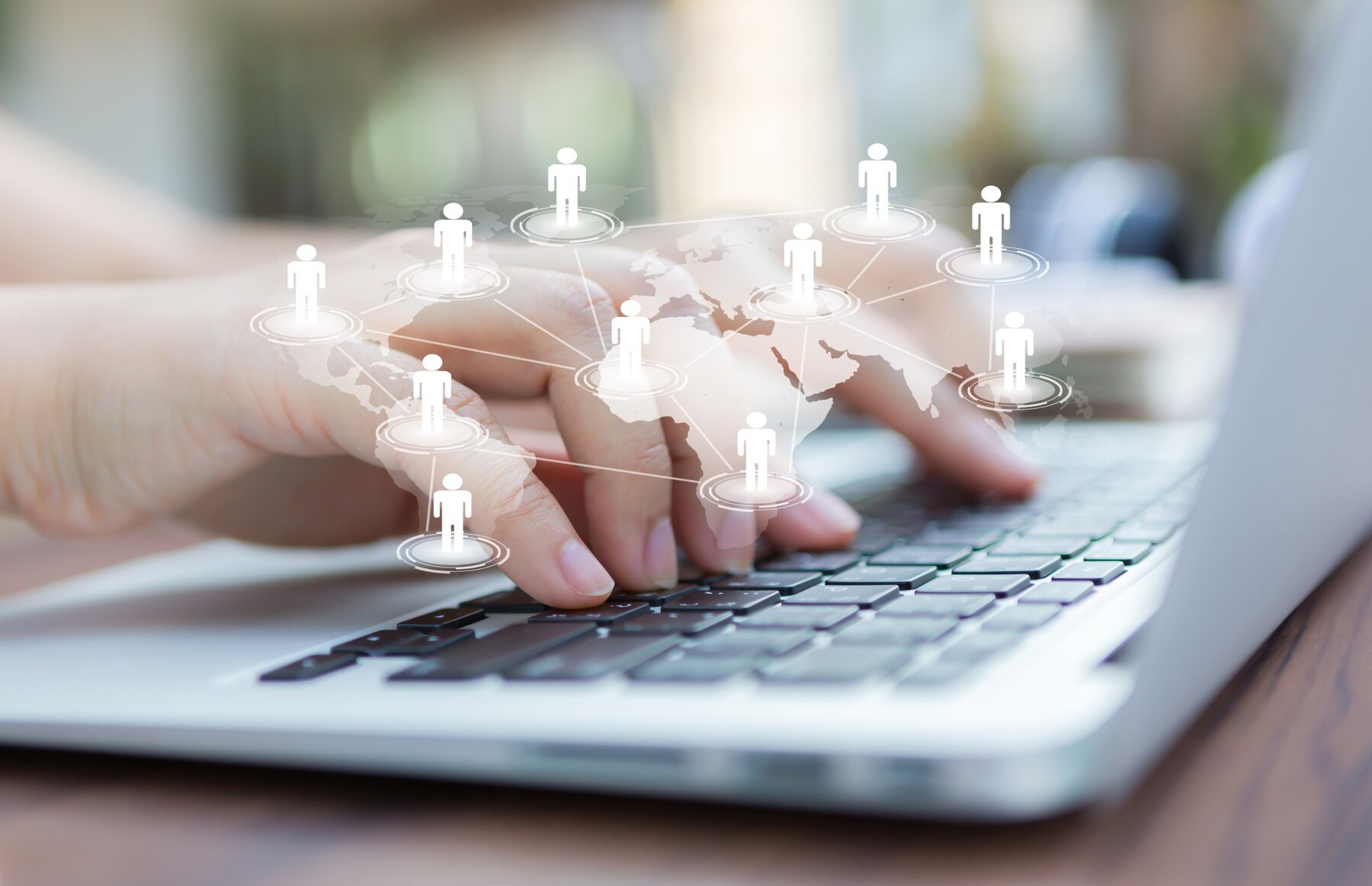 A person using a laptop with a graphic overlay showing a global network of human figures connected by lines, symbolizing online communication or social networking.