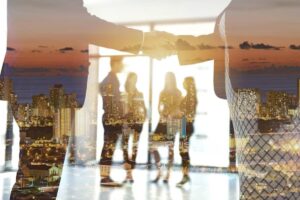 Two businesspeople shake hands against a city skyline backdrop, symbolizing partnership and collaboration in a modern office setting.